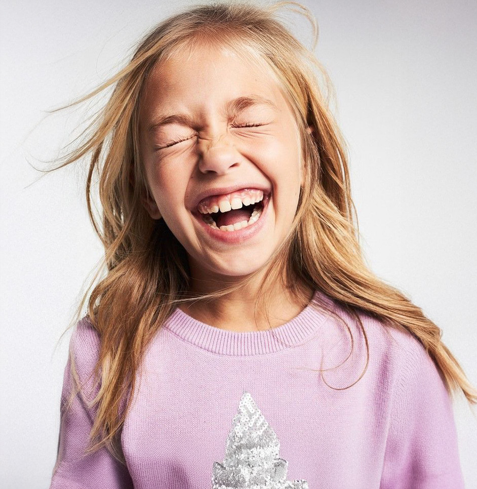 A child smiling with joy - representing the confidence that comes from unified dental care